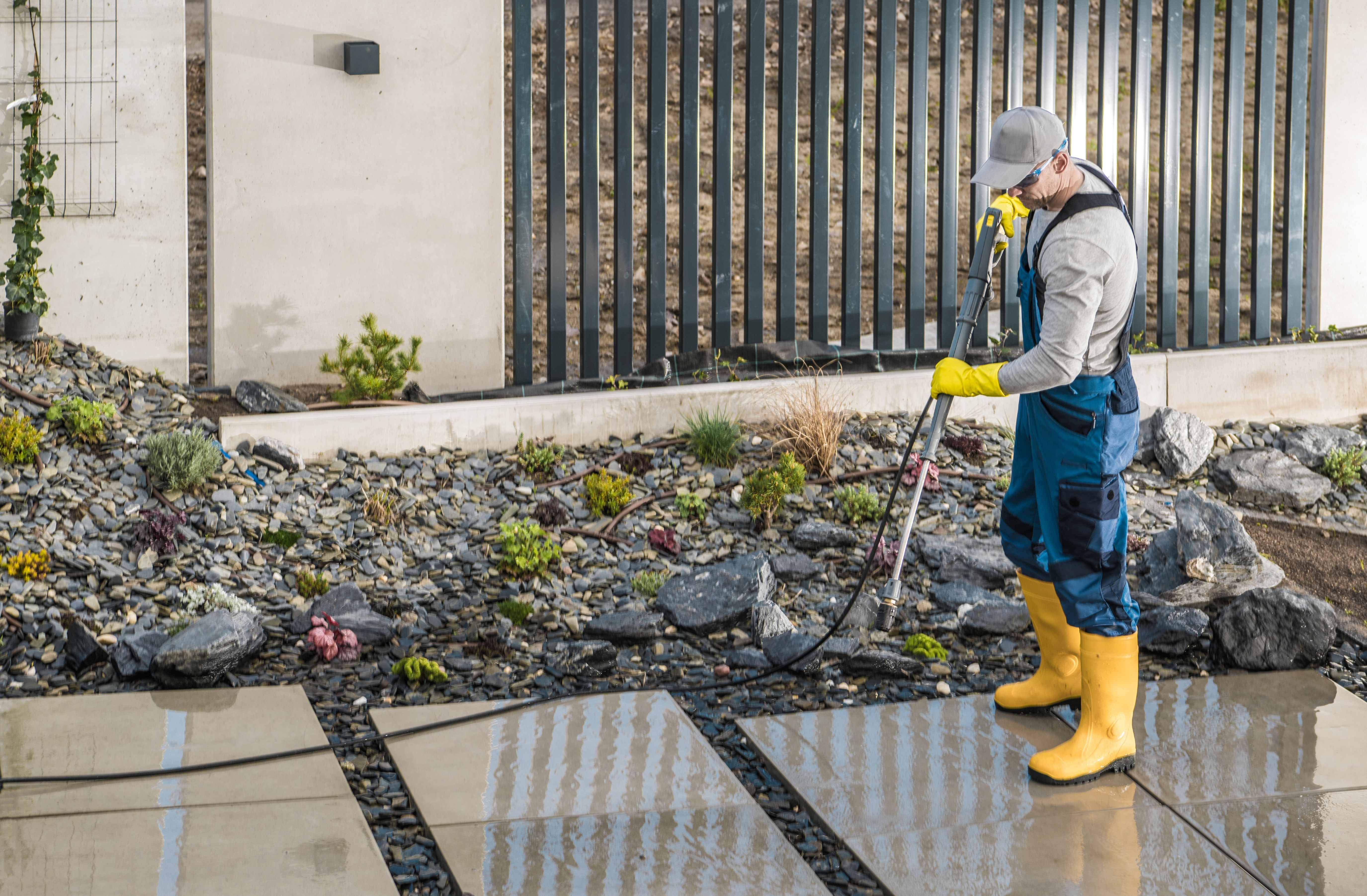 Clean pool deck with pressure washer equipment showing sparkling concrete surface next to blue pool water